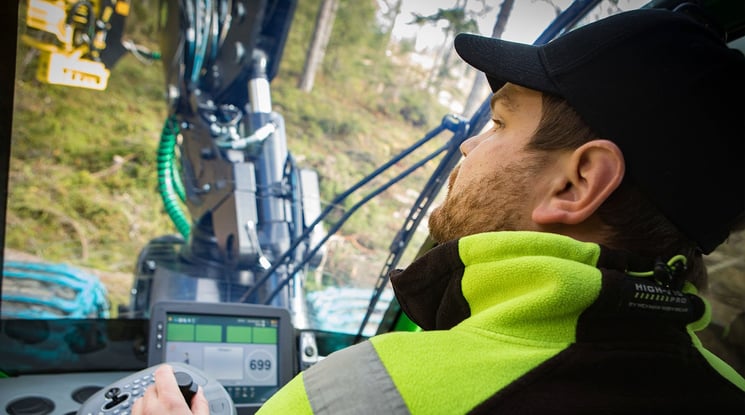 person sitter i en skördarmaskin