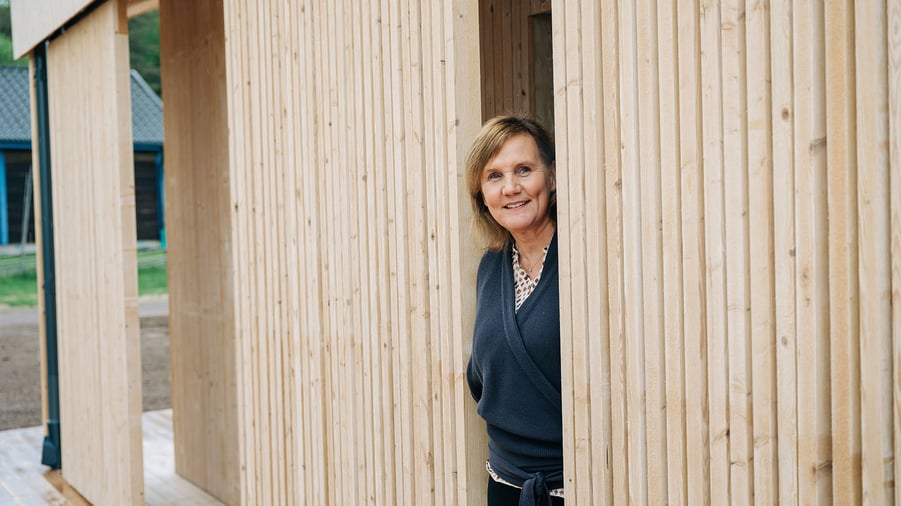 kvinna står framför trähus