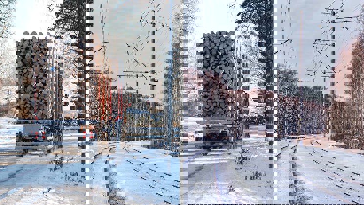 lastad timmerbil och järnväg i vinterskog