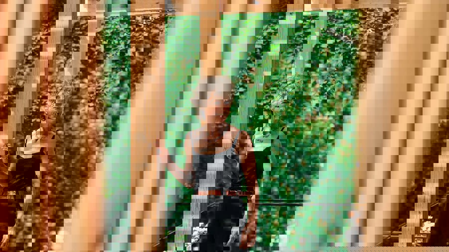 kvinna framför yogapaviljong i trä